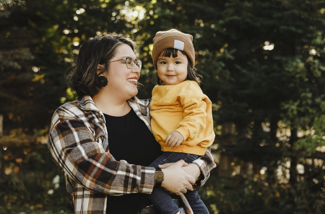 An image of a Native American two~year~old girl and her mother, outside.