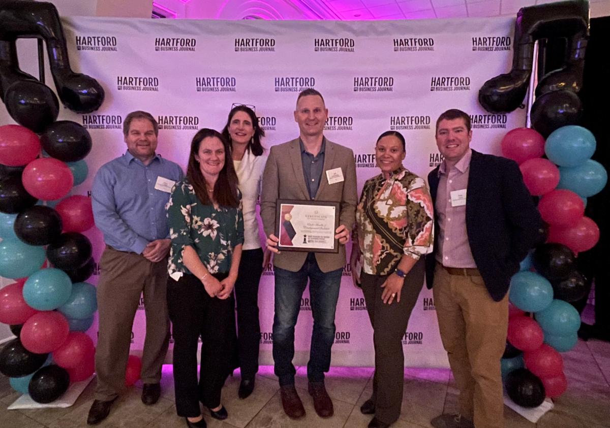 A group of CHDI staff pose with the 2023 HBJ Best Places to Work Award at a ceremony.